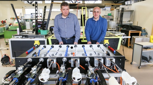 EPFL-student-professor-playing-against-foosball-table-robot